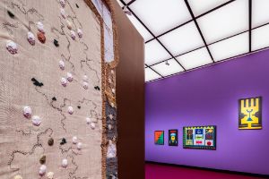 Marie-Claire Messouma Manlanbien, #Map&nbsp;&ndash; Ce corps est le n&ocirc;tre&nbsp;&nbsp;[This Body is Ours] (2021), jute fibre, hair, scraper, raffia fibre, aluminum, copper, resin, kita, 123 x 257 cm. Courtesy of Galerie C&eacute;cile Fakhoury, Abidjan, Dakar and Paris. Rubem Valentim, Emblema V (1973), painting, acrylic on canvas, 120 x 73 cm. Courtesy of Estate Rubem Valentim and Mendes Wood DM,&nbsp;S&atilde;o Paulo, Brussels, New York. Abdias Nascimento, Ponto Riscado da Liberdade (Sacred Sign for Freedom) (1974), painting, acrylic on canvas, 202 x 102 cm; Quilombismo (Exu e Ogum) (Kilombism (Eshu and Ogun)) (1980), painting, acrylic on canvas, 71 x 56 cm, Afro Estandarte (African Standard) (1993), Malerei, Acryl auf Leinwand, 80 x 50 cm; Teogonia Afro-Brasileira n. 2: Ias&atilde;, Obatal&aacute;, Oxum, Ox&oacute;ssi, Yemanj&aacute;, Ogum, Ossaim, Xang&ocirc;, Exu&nbsp;(Afro-Brazilian Theogony no. 2: Iansan, Obatala, Oshun, Oshossi, Yemanja, Ogun, Osanyin, Shango, Eshu) (1972), painting, acrylic on canvas, 102 x 152 cm. Courtesy of Instituto de Pesquisas e Estudos Afro-Brasileiros IPEAFRO Museu de Arte Negra. Installtion view of the exhibition, Haus der Kulturen der Welt (HKW), 2023.
