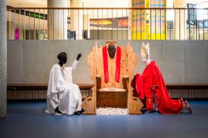 Victor Ehikhamenor, The Penance Room (2024), installation, confessional booth, two mannequins, clothing, acrylic paint on wall, dimensions vary
