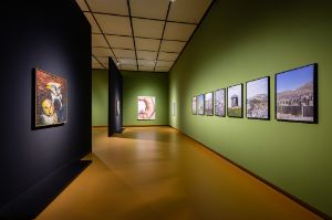 [Linke Wand] Hanna H&ouml;ch,&nbsp;Wilder Aufbruch (1933), &Ouml;l auf Leinwand, 94 &times; 82 cm; [rechte Wand] Niklas Goldbach, The Next Day, aus der Serie Permanent Daylight (2019), 7 Archiv-Pigmentdrucke auf Kunstdruckpapier, gerahmt, je 76,4 &times; 51,2 cm;&nbsp;[R&uuml;ckwand] Maria Lassnig, Schaffot der Eliten / Die Elite ist immer in Gefahr (1995),&nbsp;&Ouml;l auf Leinwand, 200,6 &times; 150,2 cm

