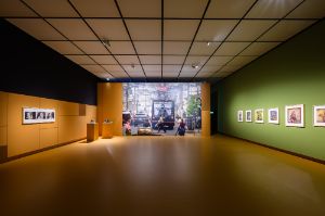 [Linke Wand] Anna Maria Maiolino, &Eacute; o que sobra (What is Left Over), aus der&nbsp;Serie Fotopoema&ccedil;&atilde;o (Photopoemaction, 1974, gedruckt 2009); [Sockel] Robin Rhode,&nbsp;Impis I - XIII (2008), 2 Helme aus Gussglas, Kunststoff, Stahl; [R&uuml;ckwand]&nbsp;Daniel Hern&aacute;ndez-Salazar,&nbsp;The Traveler (2013), Fotografie auf Tapete, 440 &times; 660 cm; [rechte Wand] Sliman Mansour, von links nach rechts: Camel of Hardship (1973), Druck auf Papier, 58 &times; 37,5 cm; Land Day (2020), Druck auf Papier, 54 &times; 39,5 cm; Untitled (1984), Druck auf Papier, 58 &times; 50 cm; The Village Awakens (1987), Druck auf Papier, 53 &times; 41,5 cm;&nbsp;Olive Picking (2021), Druck auf Papier, 67 &times; 58 cm;&nbsp;Salma (1980), Druck auf Papier, 52 &times; 42 cm; Memory of Places (2009), Druck auf Papier, 55 &times; 44 cm

