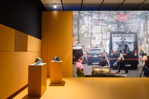 Robin Rhode,&nbsp;Impis I - XIII (2008), 2 Helme aus Gussglas, Kunststoff, Stahl; Daniel Hern&aacute;ndez-Salazar,&nbsp;The Traveler (2013), Fotografie auf Tapete, 440 &times; 660 cm

